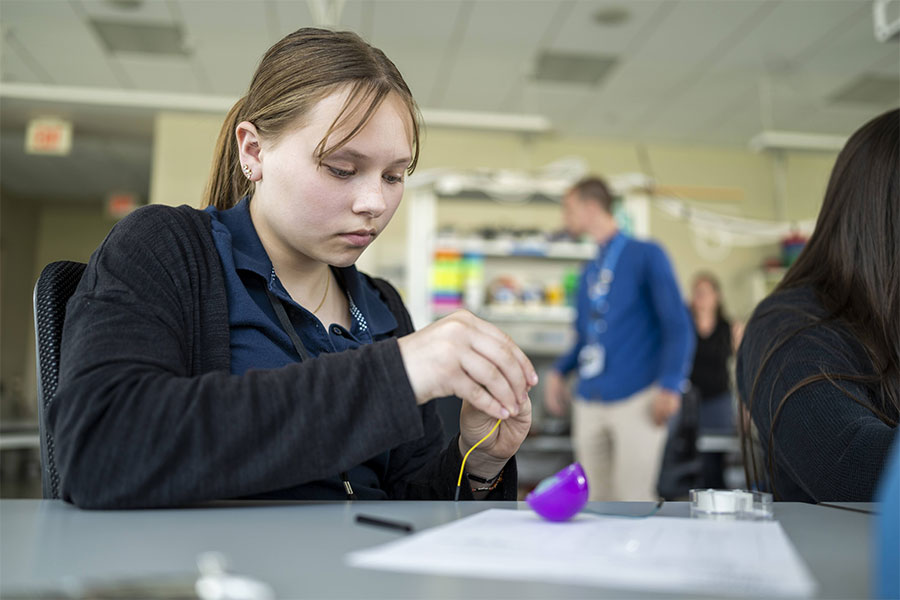 A participant builds a triboelectric nanogenerator, a simple tool that can generate electricity when shaken.
