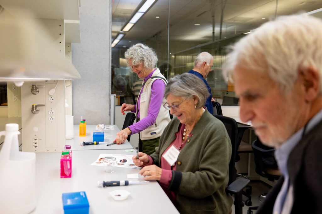 Attendees conduct a chromatography experiment comparing the composition of pen ink and candy coating dye.