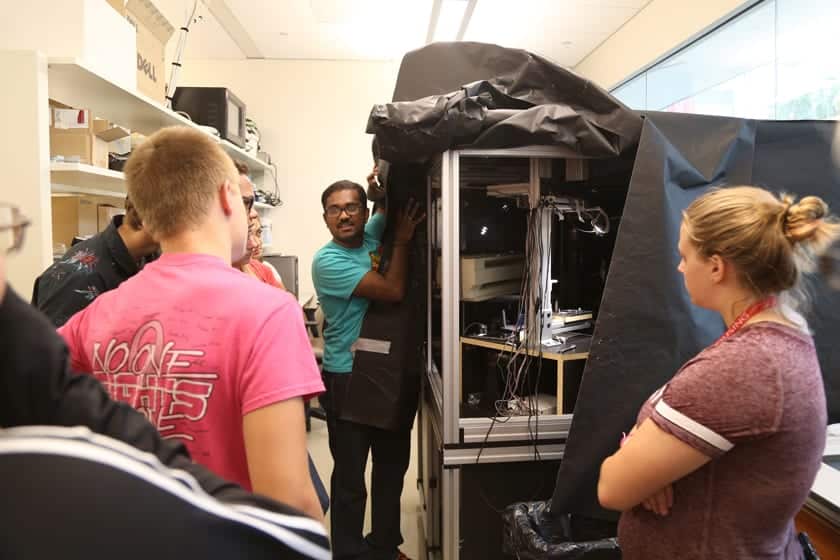 Sailendharan Sudakaran from the Vetsigian group at the Wisconsin Institute for Discovery shows off a microscope built in-house for studying microbial interactions. Campers prepared petri dishes of bacteria that they then viewed under this microscope.