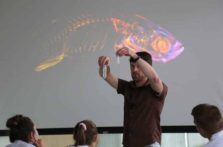 Kurt Weiss, a postdoctoral researcher in the Huisken Lab at Morgridge, discusses lightsheet and fluorescence microscopy with campers.