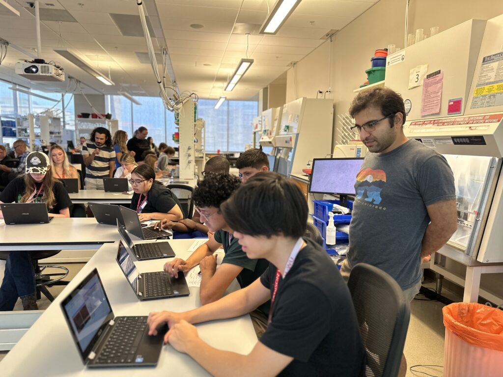 Kayvan Samimi, an assistant scientist in the Skala Lab, assists students as they view fluorescent cells using the ImageJ software.